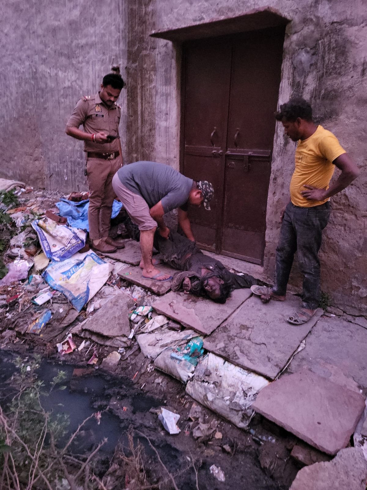 आगरा के खंदौली में एक तालाब से अज्ञात कबाड़ बीनने वाले का शव निकालते पुलिसकर्मी।